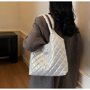 Dettaglio della borsa tote trapuntata bianca lucida con etichetta FASHION in vista