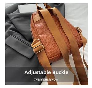 Macro view of woven leather texture on brown backpack with golden adjustable buckle