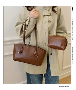 Close-up of brown faux leather tote and small pouch set with knotted strap detail