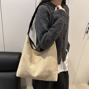 Chic beige suede tote bag with brown leather trim shown as a large shoulder hobo bag