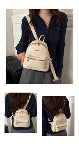 Detailed close-up of a mini beige woven backpack with elegant gold zippers and hardware