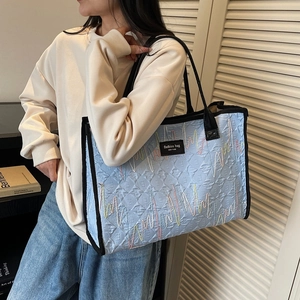 Light blue quilted tote bag with colorful wave embroidery for daily commute fashion