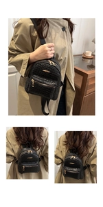 Close-up of black woven leather mini backpack with golden zippers on a tan coat