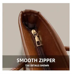 Detailed close-up of premium brown leather tote bag with a smooth golden metal zipper
