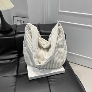 Grand sac cabas femme en velours côtelé crème, sac fourre-tout chic sur canapé en cuir