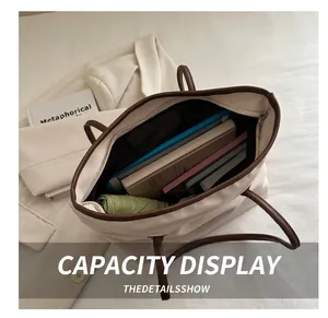 Top view of spacious interior of the beige tote bag showing books and a green umbrella