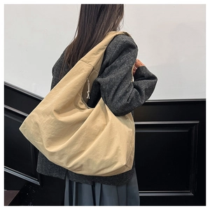 Detail einer großen khakifarbenen Nylon-Halbmondtasche mit Struktur und Knotenzipper