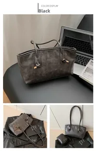 Detail of black pebbled PU leather tote with knot handle and Fashion & Bags embossed text