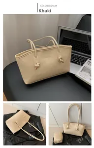 Detail of khaki leather tote bag featuring slim straps and metal knot buckle detail