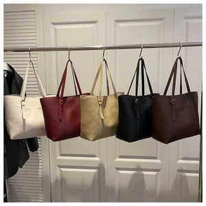 Détail de grands sacs fourre-tout montrant la texture du cuir et les sangles réglables