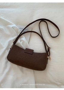 Detail of dark brown retro shoulder bag in textured matte felt on a white background