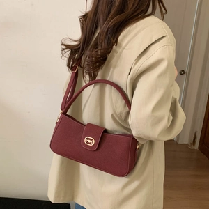 Burgundy baguette shoulder bag with gold horsebit hardware worn with a beige blazer