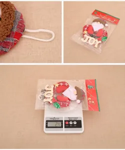 Detail of Santa plush ornament with red plaid base and JOY wood sign for Christmas tree