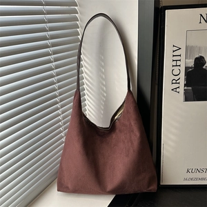 Minimalist deep burgundy suede tote bag with slim shoulder straps in a minimalist setting