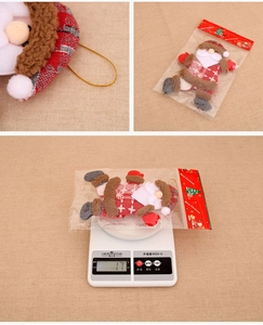 Detail view of plush dancing Santa ornament with red plaid fabric and golden hanging cord