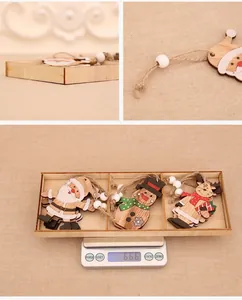 Detailed views of painted wooden Christmas ornaments with twine and beads in a tray