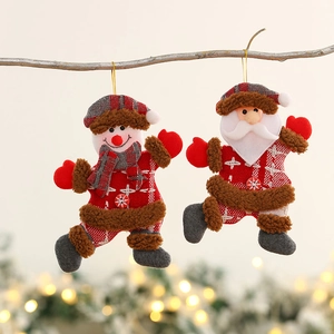 Handmade Santa and Snowman plush ornaments hanging on a rustic branch with bokeh lights