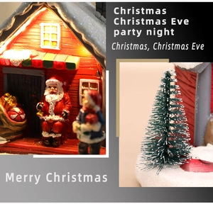 Detail of glowing LED red resin Christmas house with Santa Claus and fake snow scene