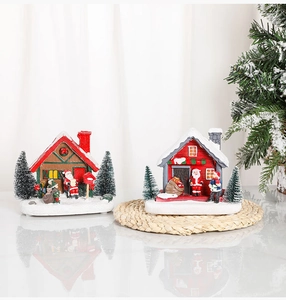 Detailed close-up of two light-up resin Christmas village houses with snowy red roofs