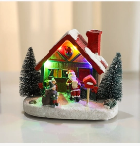 Detailed view of glowing resin Christmas house with Santa and colorful LED lights