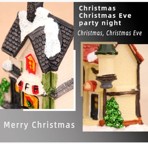 Macro shot of snow-covered resin Christmas miniature house with festive tree and wreath