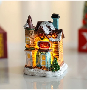 Detailed view of miniature resin Christmas toy shop with LED lights and glittery snow