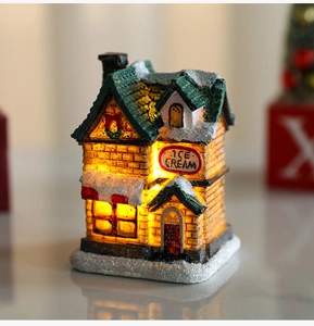 Close-up of a glowing resin Christmas ice cream shop with warm LED lights and snow details