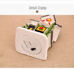 Detail view of the miniature Christmas resin house showing bottom battery case and power switch