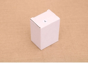 Close-up of minimalist white rectangular resin house ornament box with letter A label