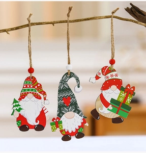 Three festive Christmas wooden gnome ornaments hanging on a dry branch for holiday decor