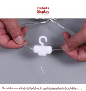 Detail of LED light string showing the white T-shape hook and transparent wiring