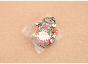Detail view of 4-pack wooden gnome ornaments in plastic packaging on burlap