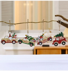 Detail of wooden Christmas truck ornaments with Santa and trees hanging on a branch