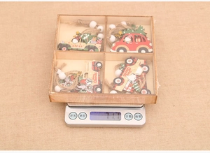 Detailed view of 12 wooden Christmas car ornaments in a box weighing 77.7g on a scale