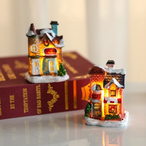 Illuminated Christmas resin village houses with snow roofs and Toy Shop Gift signage