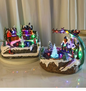 Detail of LED Christmas village scene with rotating fountain and resin winter decorations