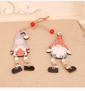 Detail view of two wooden Christmas gnome ornaments with dangling legs and nordic hats