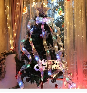 Detail of silver mesh LED ribbon with warm glowing lights wrapped on a Christmas tree