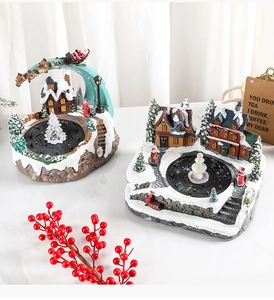 Detail view of miniature musical Christmas scene ornaments with fountain and glowing LED trees
