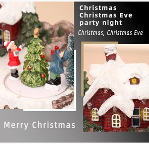 Detail of Christmas musical village featuring red cottage, snowy trees and festive figures