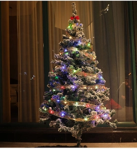Detail of Christmas tree ribbon lights with glowing colorful LEDs and snowflake mesh