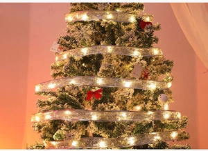 Detail of warm yellow LED Christmas ribbon lights wrapped on a festive tree branch