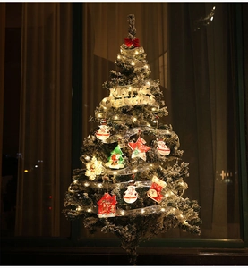 Detail of silver LED ribbon light string with warm Christmas pendants and Merry Christmas tag