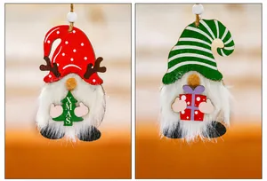 Detail view of two wooden Christmas gnomes with white faux fur beards and XMAS signs