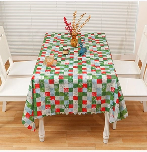Close-up of a festive red and green plaid Christmas tablecloth with white snowflake patterns