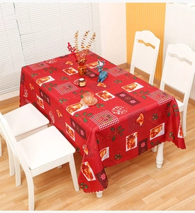 Close-up of red Christmas tablecloth with reindeer patterns and scalloped edges