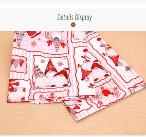 Detail view of polyester Christmas tablecloth with festive gnome and snowflake print