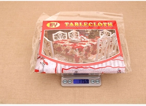 Polyester Christmas tablecloth in packaging weighed on scale at 175.9g for shipping
