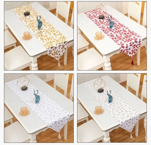 Detail of Christmas table runners with festive gold leaf patterns and decorative tassels