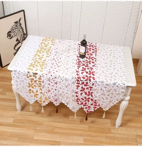 Detail of Christmas table runner with gold star embroidery and colorful tassels